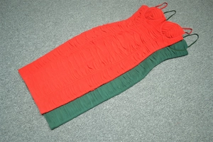 Détail de robes bandage à col en V froncées en couleurs rouge et vert foncé