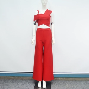 Detail of red two-piece set featuring asymmetrical crop top and high-waisted wide-leg trousers