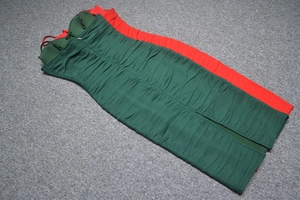 Détails des plis horizontaux sur des robes bandage moulantes rouge et vert foncé