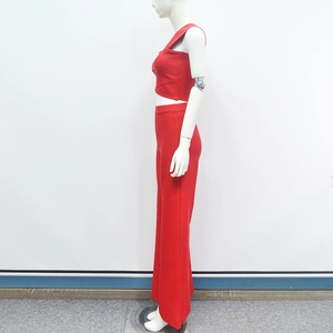 Detail of red ribbed knit texture on a sexy one-shoulder crop top and wide-leg trousers