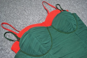 Détails de robes bandages rouge et verte avec des plis fins en tulle et fines bretelles