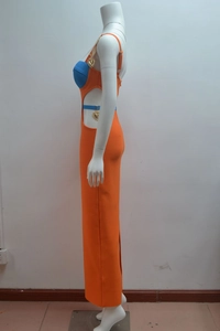 Detail of cut-out waist with heart-shaped gold chain on orange and blue bandage dress