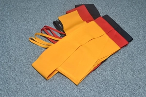 Flat lay of ribbed knit crop tops with thin straps in orange, red, and black colors