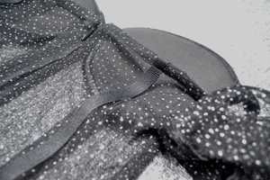 Détail d'une robe de soirée noire en tulle à pois avec fermeture éclair et bretelles fines