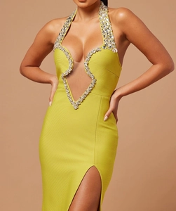 Détail de la robe bandage jaune citron avec bordure en strass et décolleté ajouré
