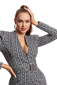 Detail of black and white geometric labyrinth pattern on dress with golden belt buckle