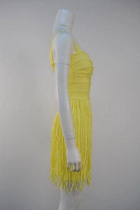 Detail view of yellow bandage dress with spaghetti straps and dynamic fringe skirt hem