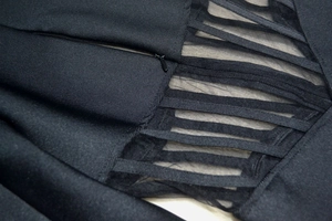 Detail of invisible zipper and sheer mesh patchwork on the black bandage dress