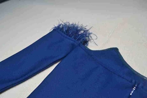 Detail of navy blue bandage dress featuring shoulder feather trim and fitted long sleeves
