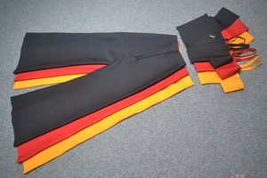 Detailed view of high-waist flared pants in black, red, and orange with side zip