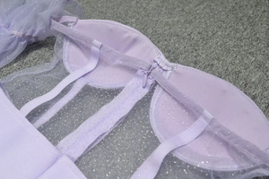 Détail d'une robe de soirée lavande avec baleines de corset, paillettes et zip invisible