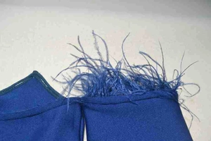 Close-up of royal blue bandage dress fabric with rib knitting and feather trim detail