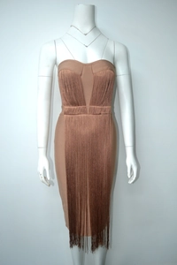 Detail view of tan strapless bandage dress featuring long tassels and bodycon fit