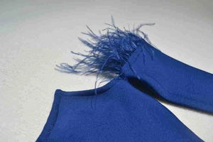 Close-up of royal blue knit bandage dress featuring elegant ostrich feather trim details