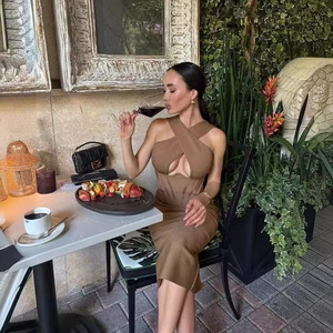 Brown knit cross halter neck cut-out backless maxi dress in a sunny outdoor restaurant