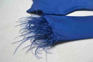 Detail of dark blue bandage dress sleeve featuring elegant ostrich feather trim