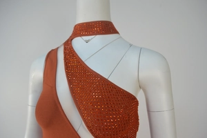 Close-up of orange sleeveless dress featuring rhinestone details and cutout design