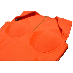 Dettaglio del tessuto bandage arancione acceso con coppe modellate e zip in metallo
