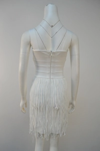 Detailed back view of white bandage dress featuring a zipper and long fringe tassels