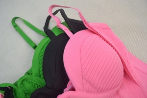 Dettaglio della trama a costine degli abiti sottoveste slim in rosa, nero e verde scuro