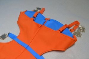 Detail of blue and orange bandage dress featuring golden heart-shaped metal charms