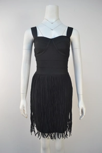 Close-up detail of black sleeveless bandage dress featuring bustier top and fringe hemline