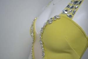Détails de strass étincelants sur l'encolure d'une robe bandage jaune de soirée