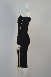Detail of side ruching and metallic gold piping on a black bodycon party dress