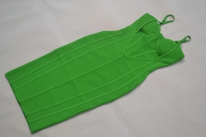 Dettaglio dell'abito fasciante verde neon con coppe modellate e design a righe incrociate
