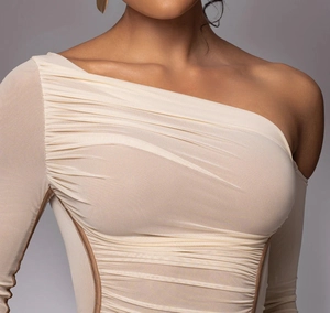 Close-up of elegant cream ruched mesh dress with one-shoulder design and refined texture