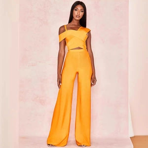 Two-piece orange bandage set featuring a crop top and high-waisted wide-leg trousers