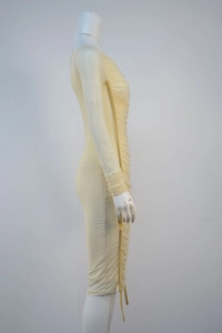 Detail view of the elegant ruching texture and soft yellow fabric on the fitted party dress