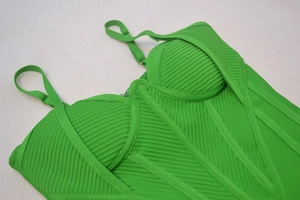 Dettaglio del tessuto bandage verde brillante con coppe strutturate e spalline sottili