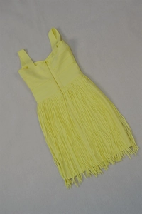 Close-up of yellow bandage dress featuring fringe hem and rear zipper closure