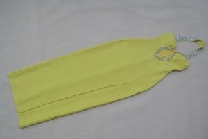 Détail de la robe bandage jaune avec encolure en strass et découpe en forme de cœur