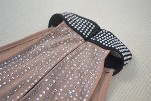 Macro detail of sheer mesh fabric with glittering rhinestones on elegant party dress