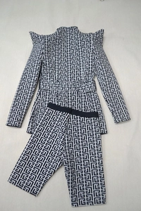 Detail of jacquard blazer suit featuring sharp shoulder pads and geometric maze pattern