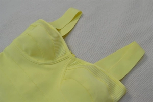 Detail view of bright yellow bandage dress with thick straps and ribbed patchwork texture