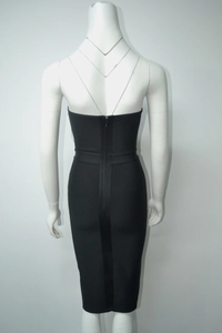 Detail view of the vertical zipper closure on a black strapless bandage dress