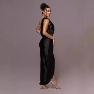 Detail of elegant black one-shoulder satin maxi dress with pleated bodice and high slit