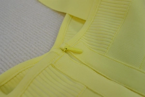 Detail of yellow bandage dress showing invisible zipper and ribbed knit fabric texture