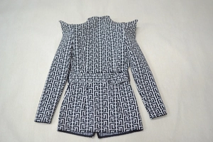 Macro view of geometric maze pattern and sharp shoulder pads on a black and white blazer