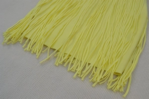 Detail of a bright yellow bandage dress featuring dense long fringe and elastic knit fabric