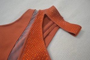 Detail of the orange bandage dress featuring mesh inserts and shimmering rhinestones