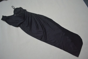 Detailed view of black strapless evening dress with pleated skirt and side slit detail