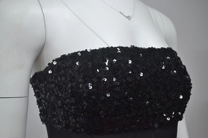 Dettaglio ravvicinato del corpetto nero senza spalline con paillettes luccicanti
