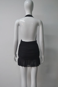 Detail of black halter mini dress featuring backless design and ruched ruffle textures