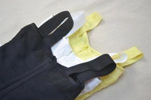 Detail of ribbed bandage mini dresses in black, white and yellow with back zippers