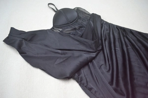 Detail of black strapless evening dress with sheer mesh panel and pleated satin fabric