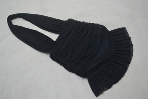 Detail of black halter sleeveless mini dress featuring ruched mesh fabric and ruffled hem